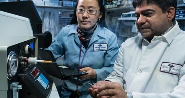 Dr. Xin Li (balra) és Dr. Deepak (jobbra) egy e-cigaretta elemzésre használható gépet tesztelnek. (Kép: Leo Sorel/NYU Photo Bureau) 